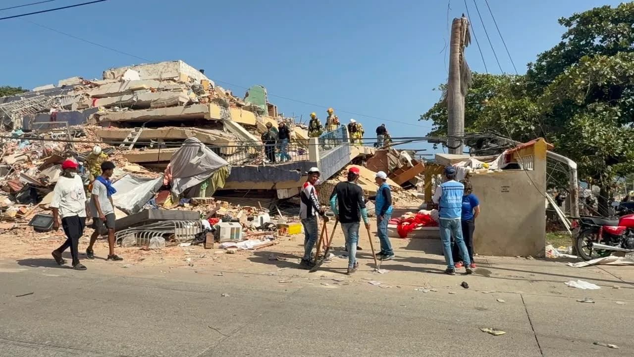 Rescatistas, voluntarios de la ONU y pobladores remueven escombros frente a un edificio colapsado.