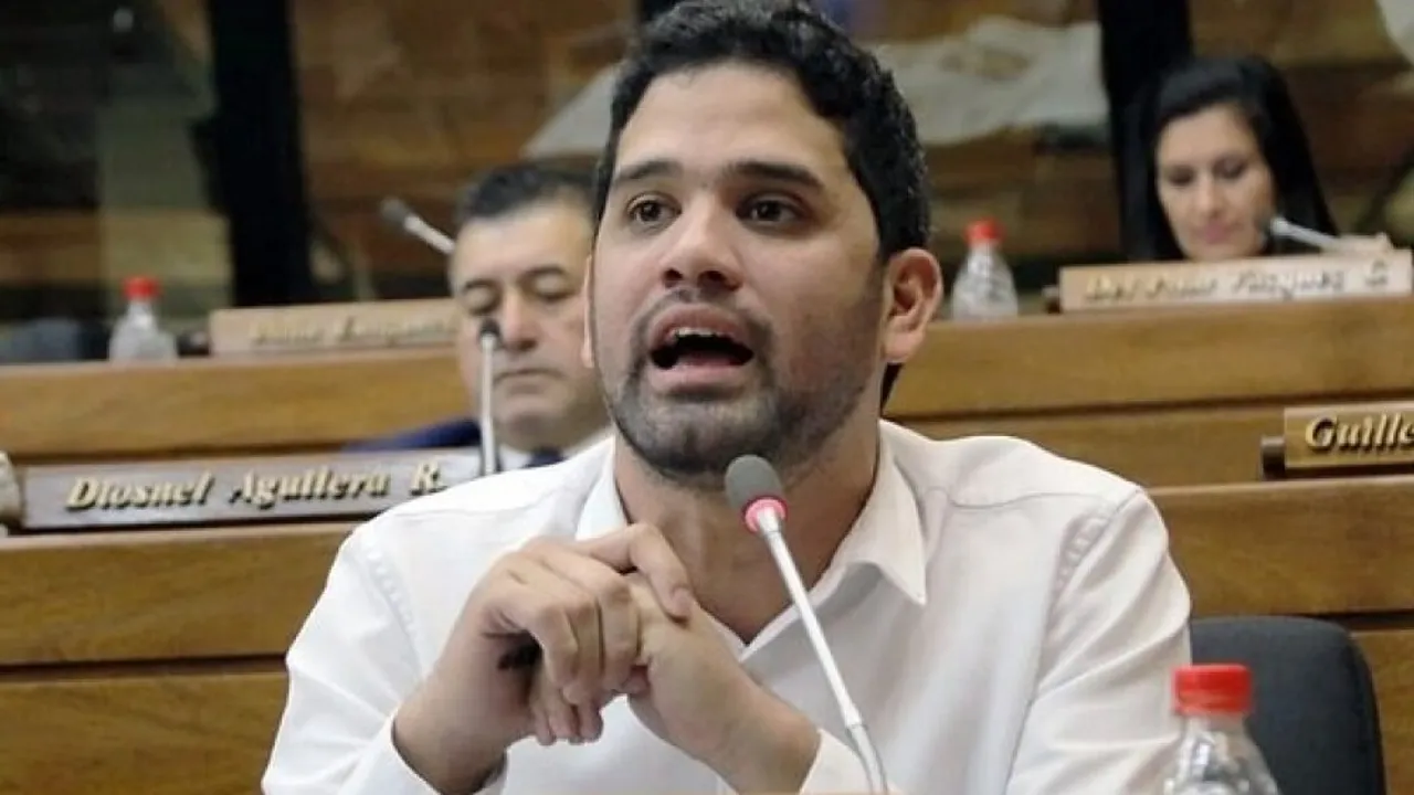 El diputado Raúl Benítez habla con las manos juntas frente a un micrófono en la sala de sesiones del Congreso.