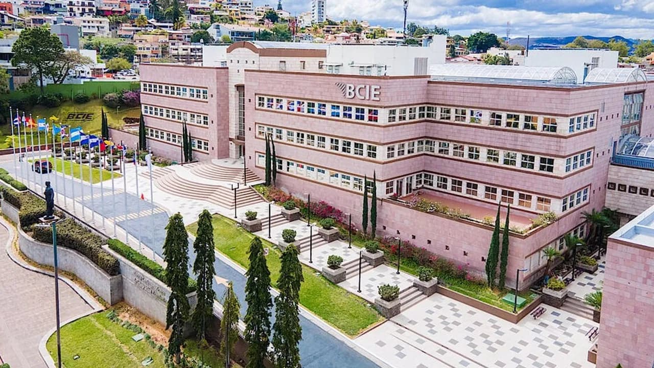 Edificio de la sede central del Banco Centroamericano de Integración Económica con banderas y jardines.