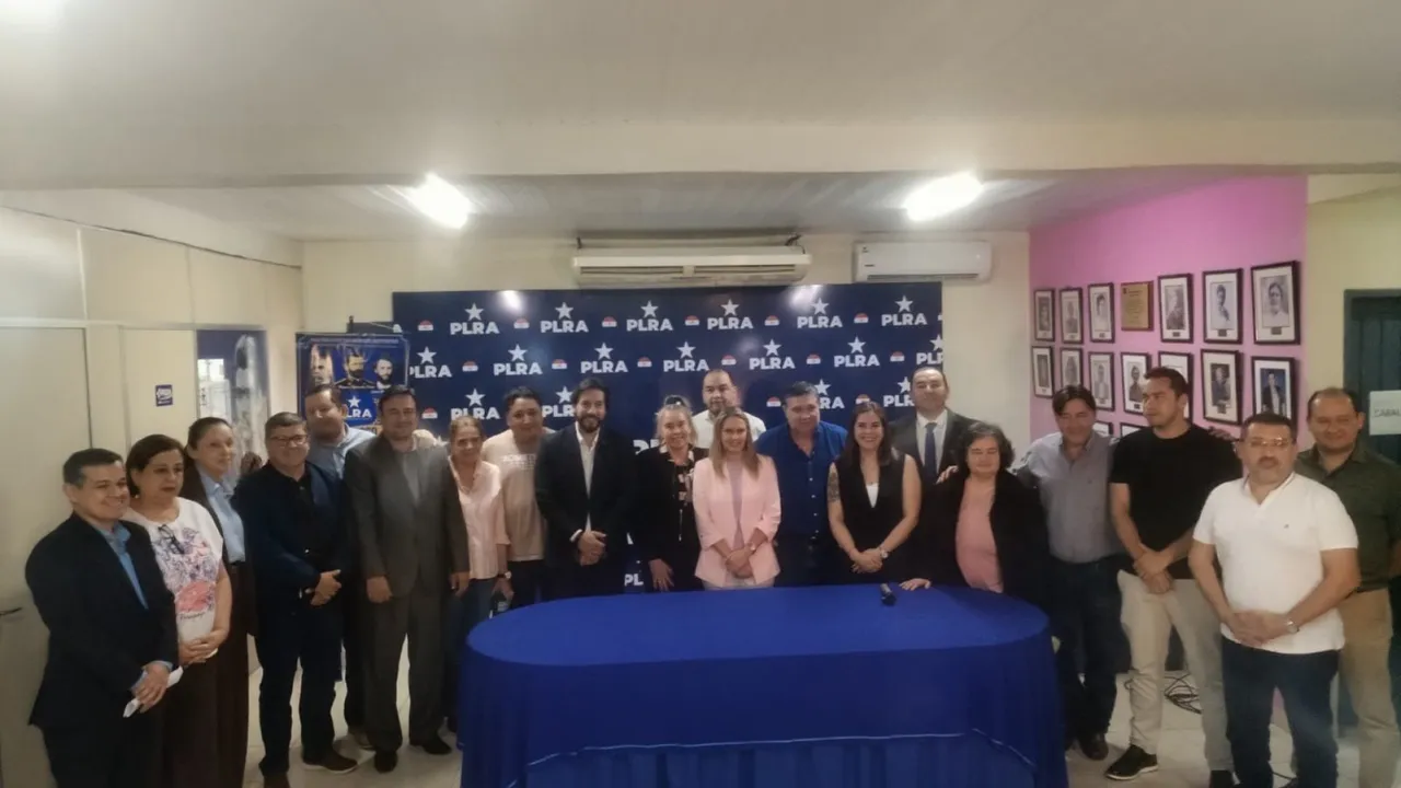 Referentes de diversos sectores políticos paraguayos reunidos frente a un cartel del PLRA en una sala de conferencias.