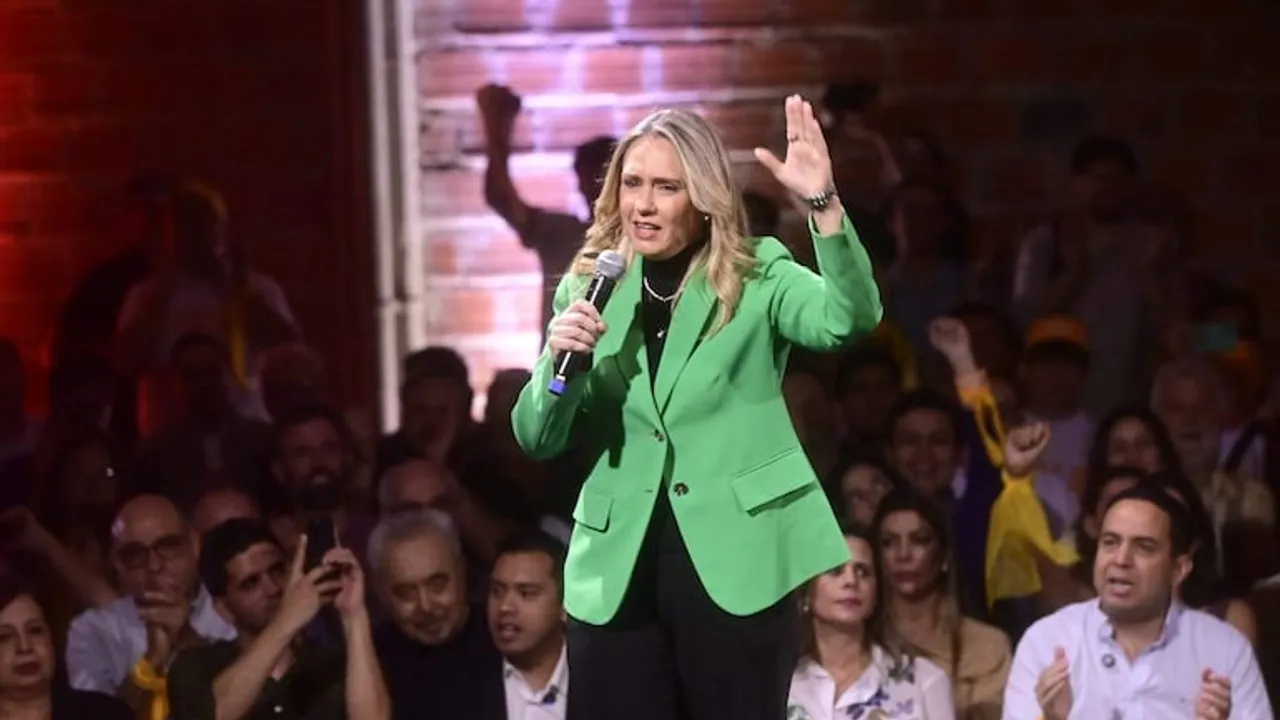 Rocío Vallejo vestida de saco verde habla con un micrófono en mano durante un acto político ante el público.