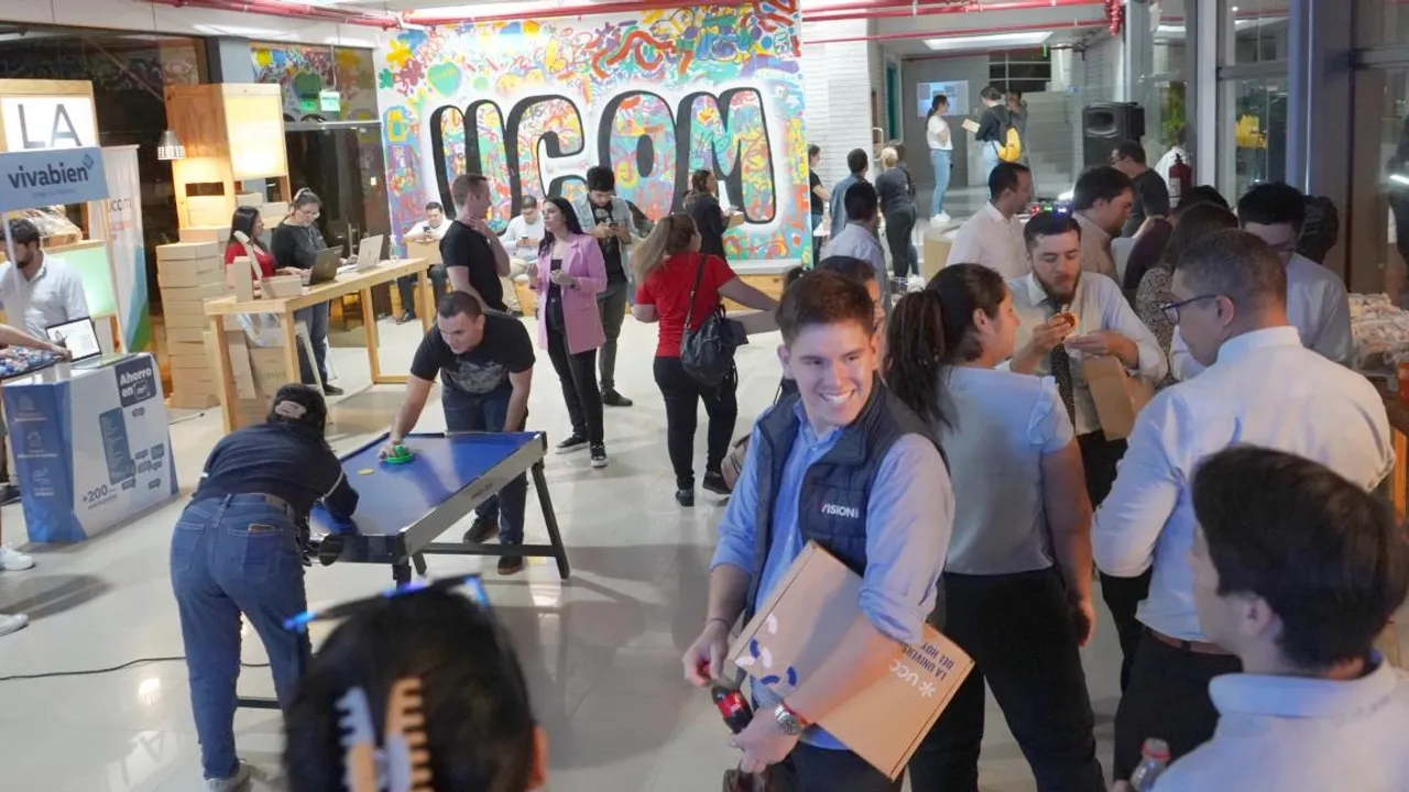 Grupo de jóvenes universitarios compartiendo y conversando en un espacio recreativo interior con un mural decorativo.