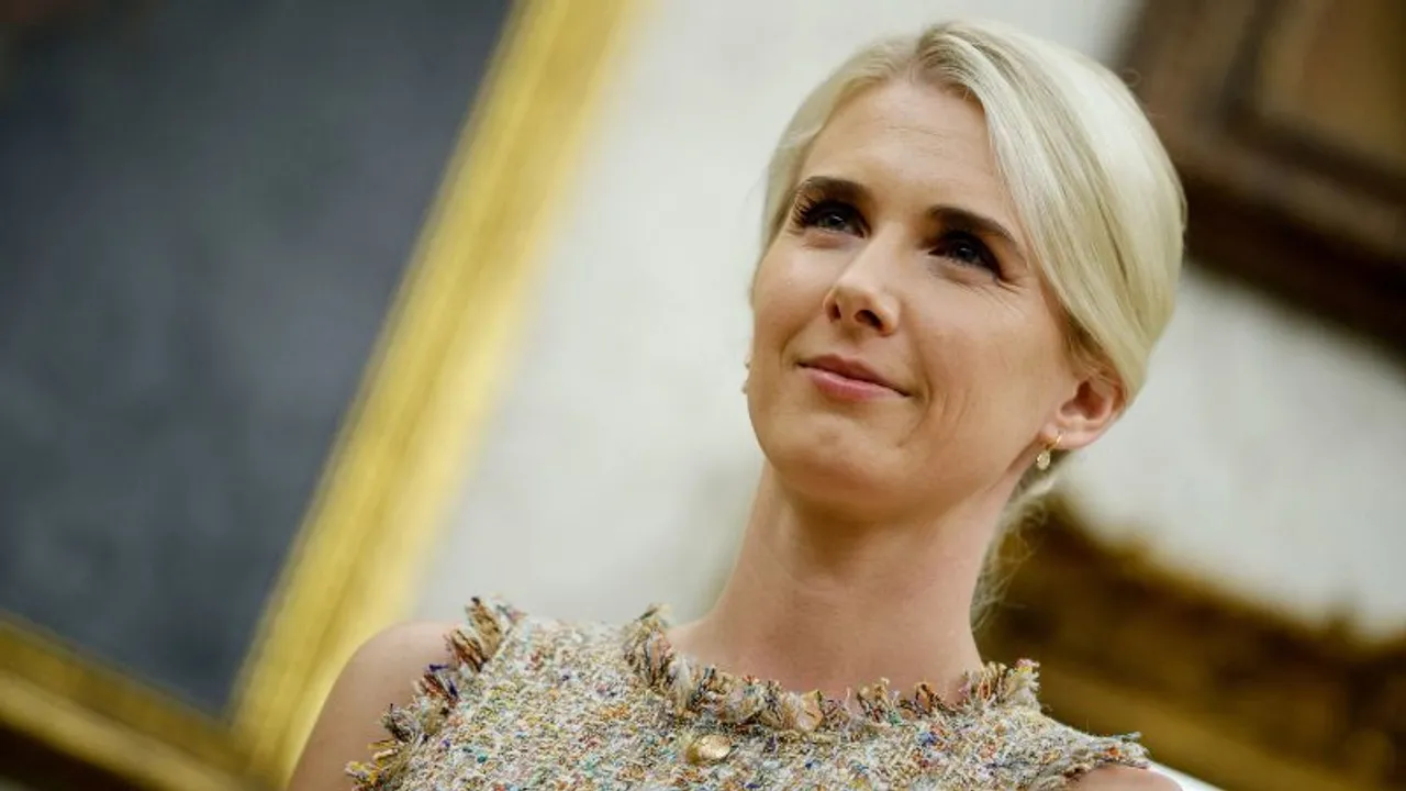 Natalie Harp, asesora del gobierno estadounidense, sonríe de perfil luciendo un peinado recogido en un salón oficial.