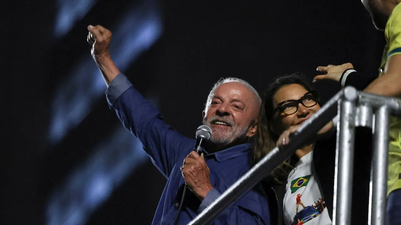 Luiz Inácio Lula da Silva levanta el puño y habla por micrófono en un escenario junto a su esposa durante los festejos.
