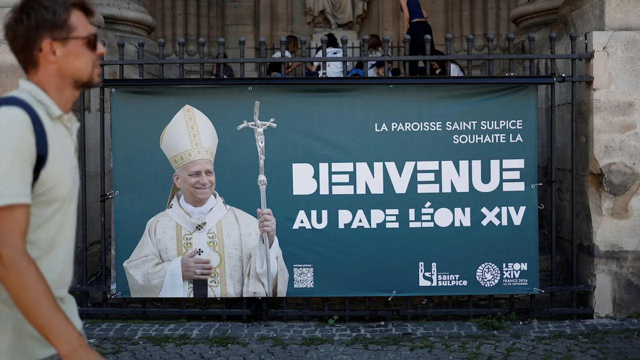 Cartel que da la bienvenida al papa León colocado en las rejas exteriores de un templo en París.