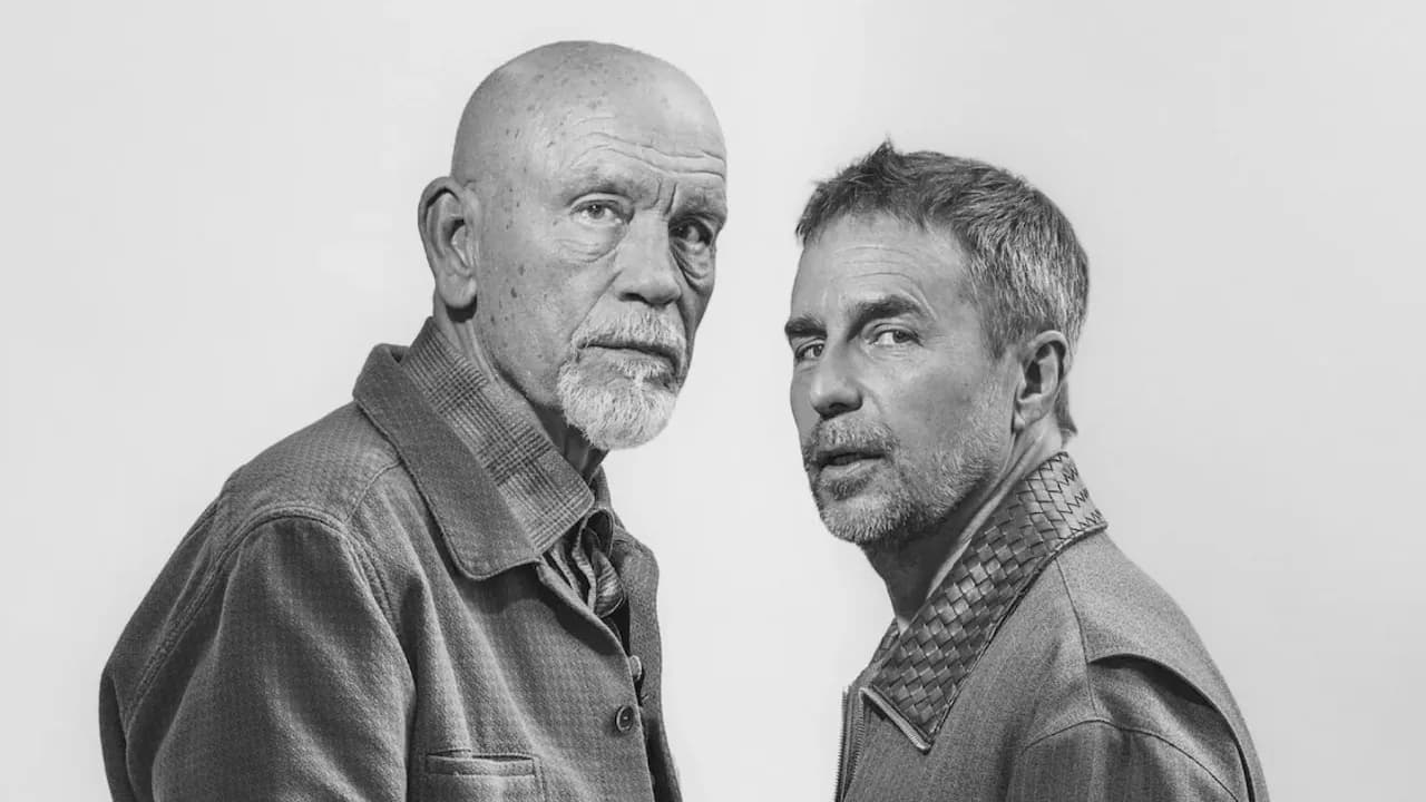 Retrato en blanco y negro de dos hombres adultos mirando fijamente a la cámara con expresiones serias sobre fondo claro.