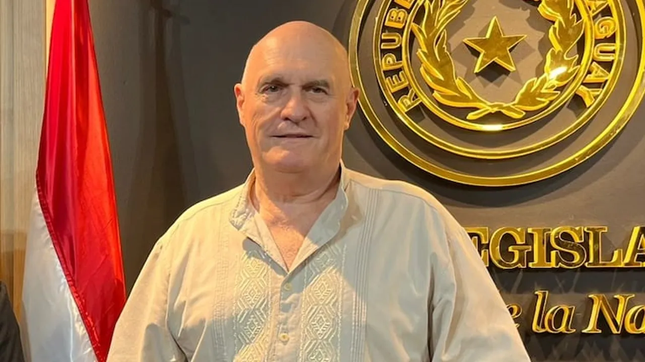 Walter Kobylanski viste una camisa clara frente al escudo nacional dorado en la sede del Congreso paraguayo.